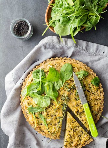 Top view of sliced gluten-free vegan quiche with salad.