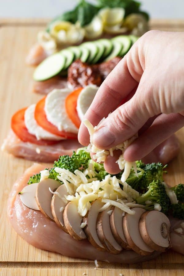 These stuffed chicken breast recipes are all quick and easy to make for a weeknight dinner. Juicy, pan-seared chicken breasts with your choice of 4 stuffing options. #stuffedchickenbreast #onepandinners placing fillings on a chicken breast to create Broccoli Cheese Stuffed Chicken Breasts