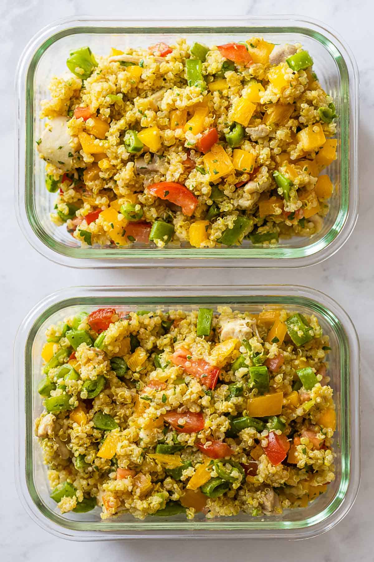 Two Chicken Quinoa Meal Prep Bowls on a kitchen counter.
