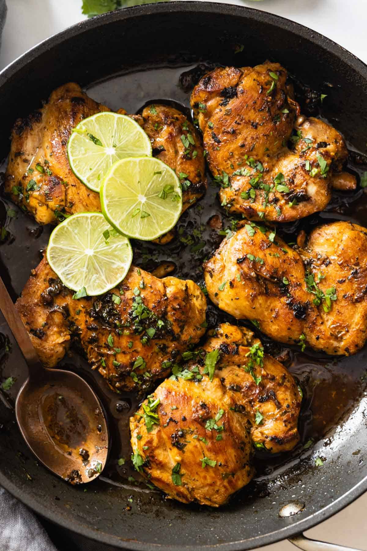Closeup shot of texture of cooked cilantro lime chicken thighs in a pan.